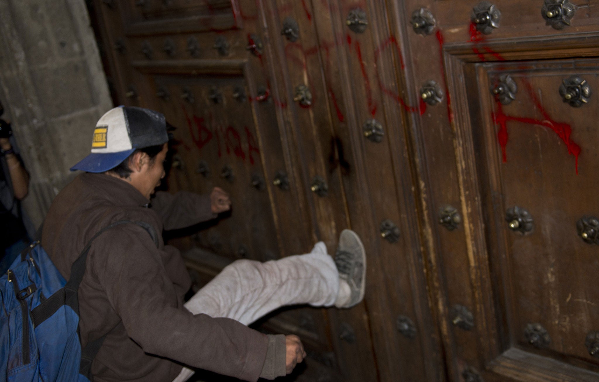 A demonstrator tries to tear down the main entrance of the National Palace at the Main Square