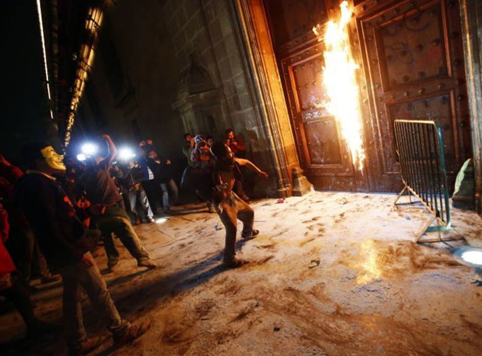A group of protesters set fire to the wooden door of Mexican President Enrique Pena Nieto's ceremonial palace