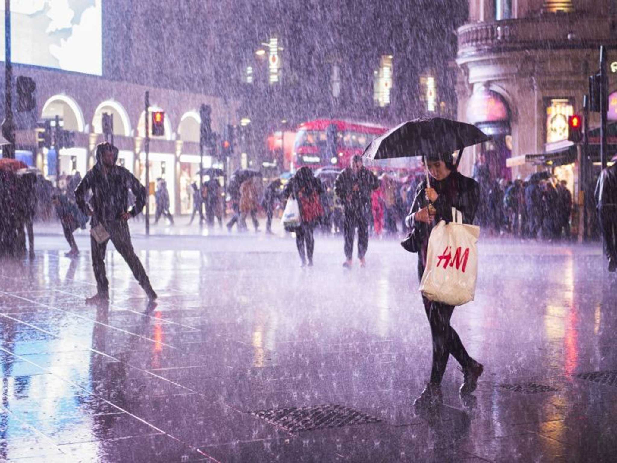 A woman walks through the rain in central London on Saturday