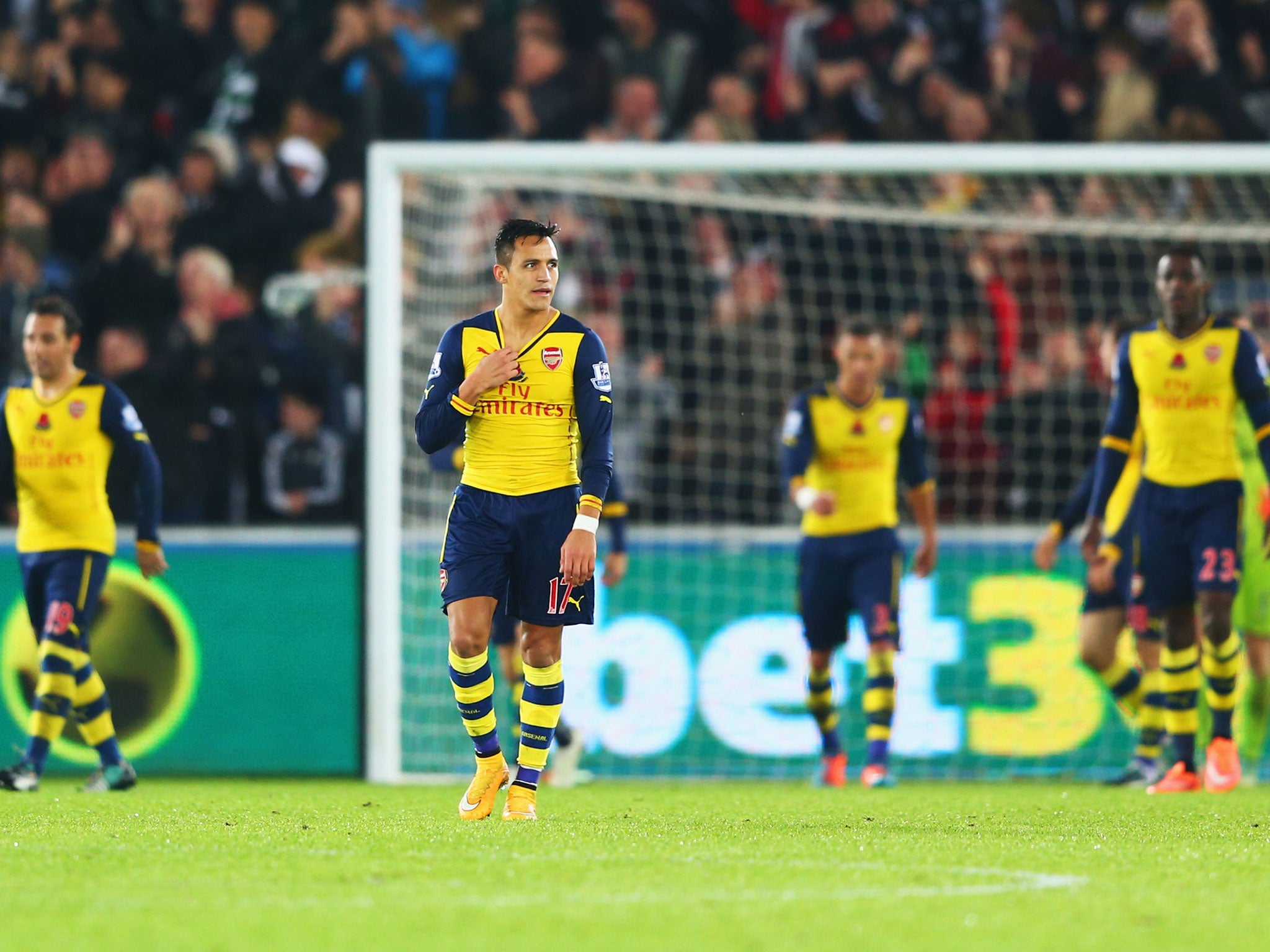 Alexis Sanchez of Arsenal (17) and team mates look dejected as they concede a goal during the Barclays Premier League match between Swansea City and Arsenal at Liberty Stadium on November 9, 2014 in Swansea, Wales.