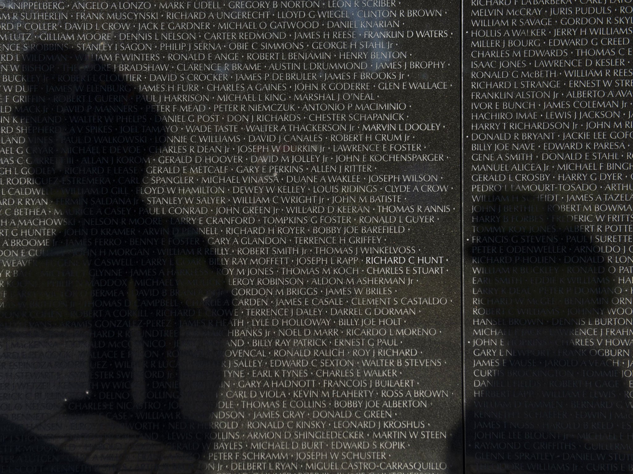 The shadows of members of the US Army appear on the wall of the Vietnam Veterans Memorial on the National Mall in Washington, DC, on the eve of Veterans Day