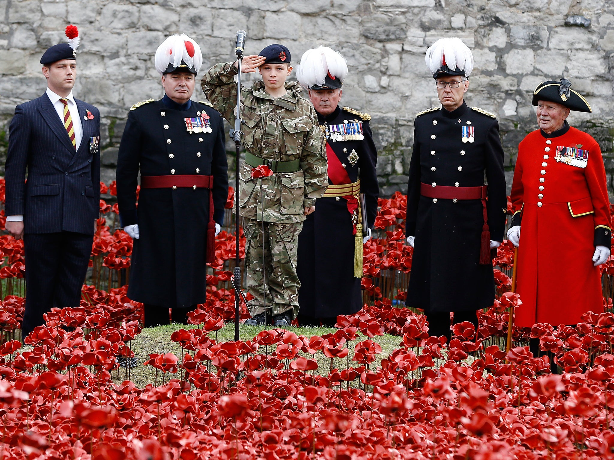 Cadet Harry Alexander Hayes salutes after he plants the last poppy during a remembrance day ceremony into the ceramic poppy art installation by artist Paul Cummins entitled 'Blood Swept Lands and Seas of Red' in the dry moat of the Tower of London