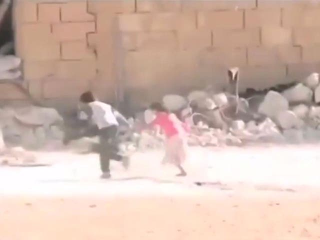 The boy pulls the girl behind a building and away from sniper fire 