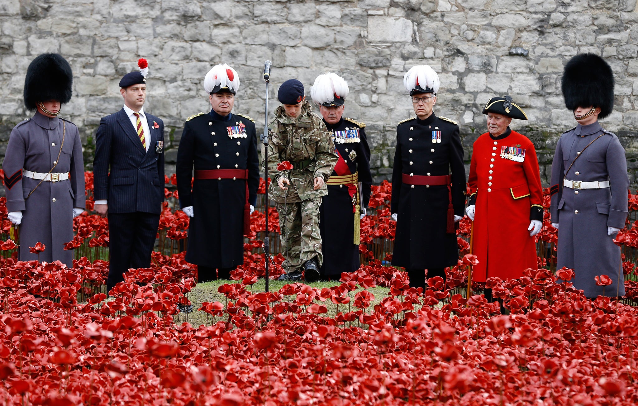 Cadet Harry Alexander Hayes plants the last poppy during a remembrance day ceremony into the ceramic poppy art installation by artist Paul Cummins entitled 'Blood Swept Lands and Seas of Red' in the dry moat of the Tower of London
