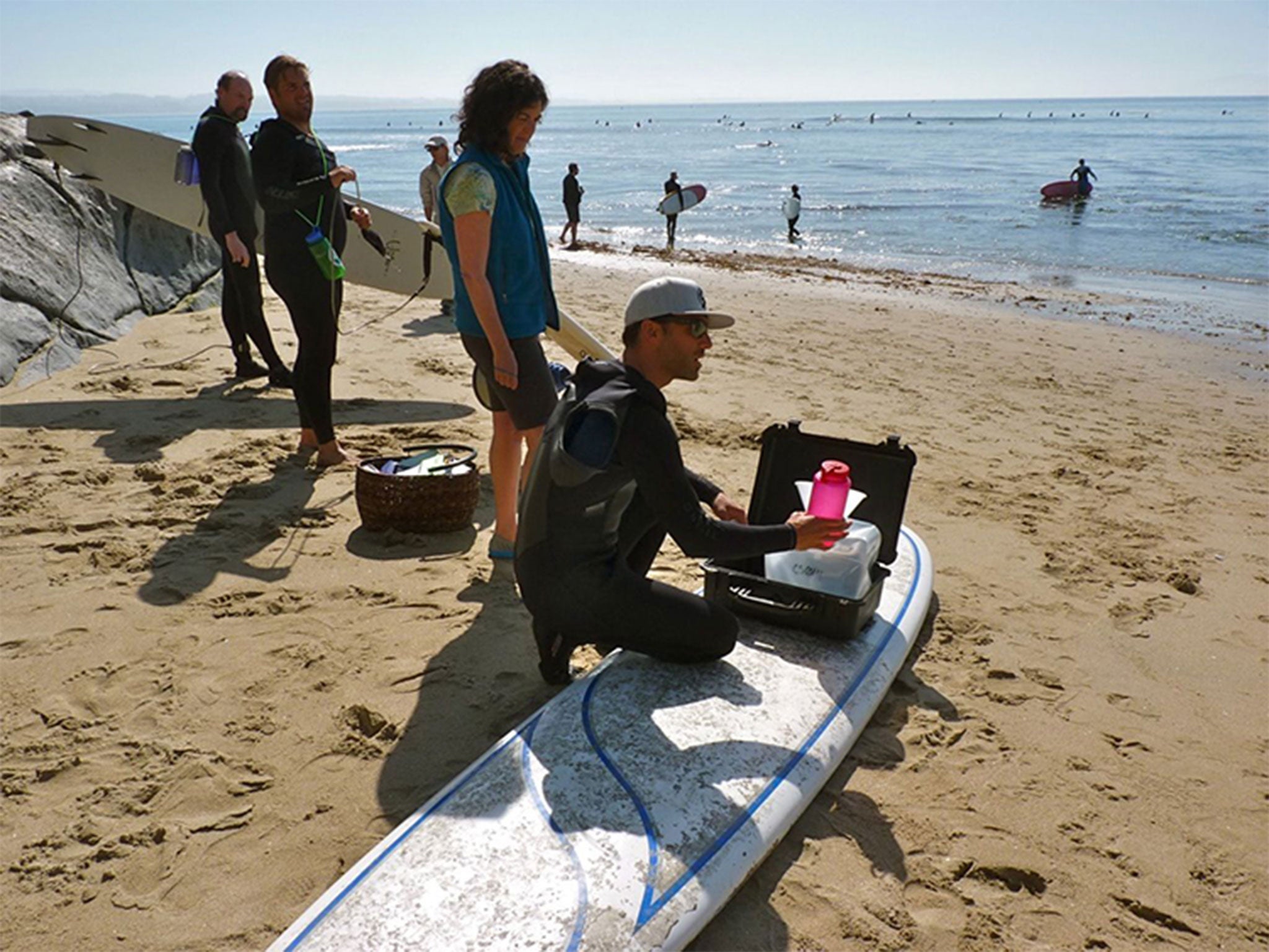Surfers gather a water sample at Pleasure Point in Santa Cruz, California