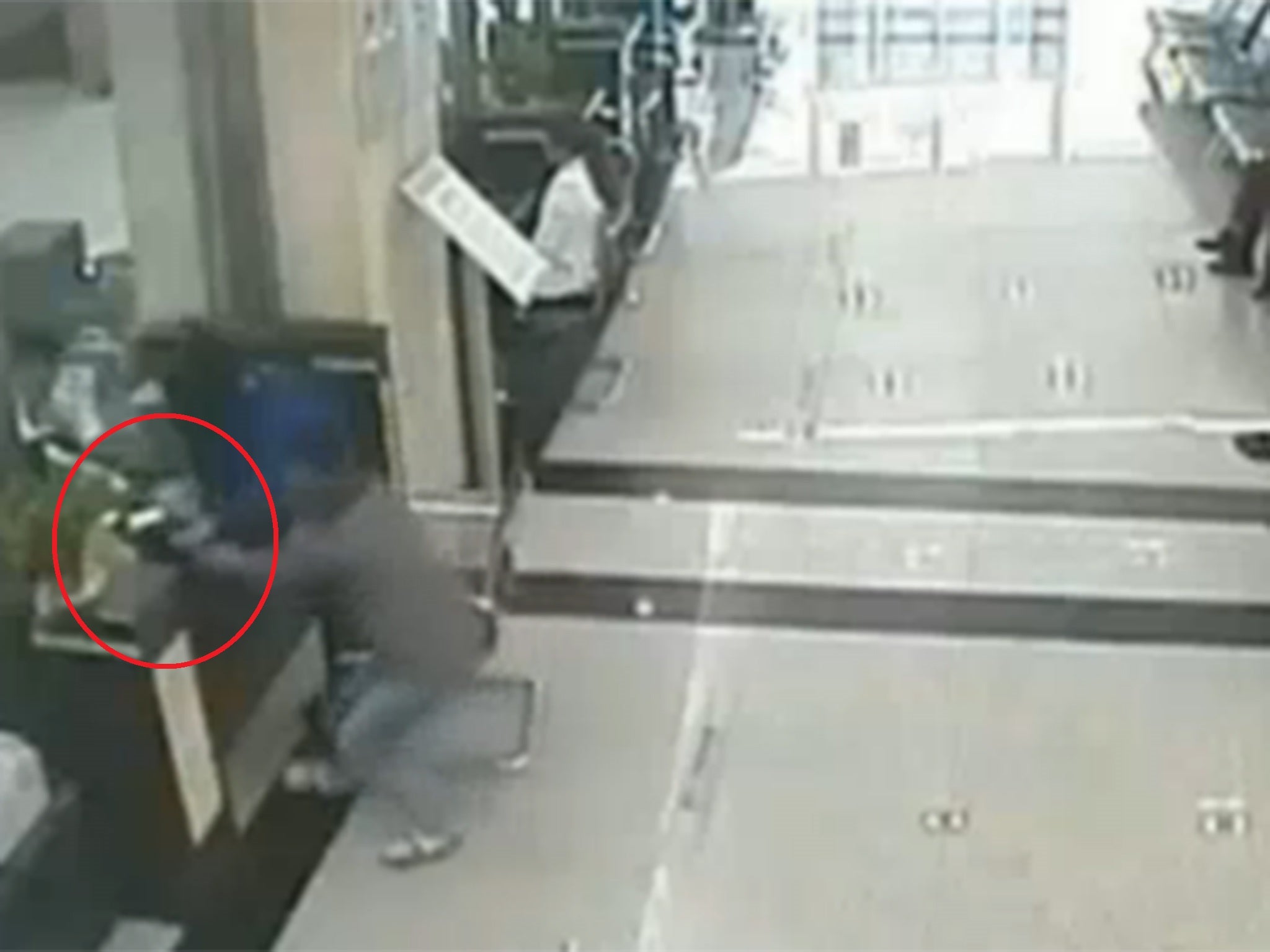The moment the robber grabs the cash and handbag