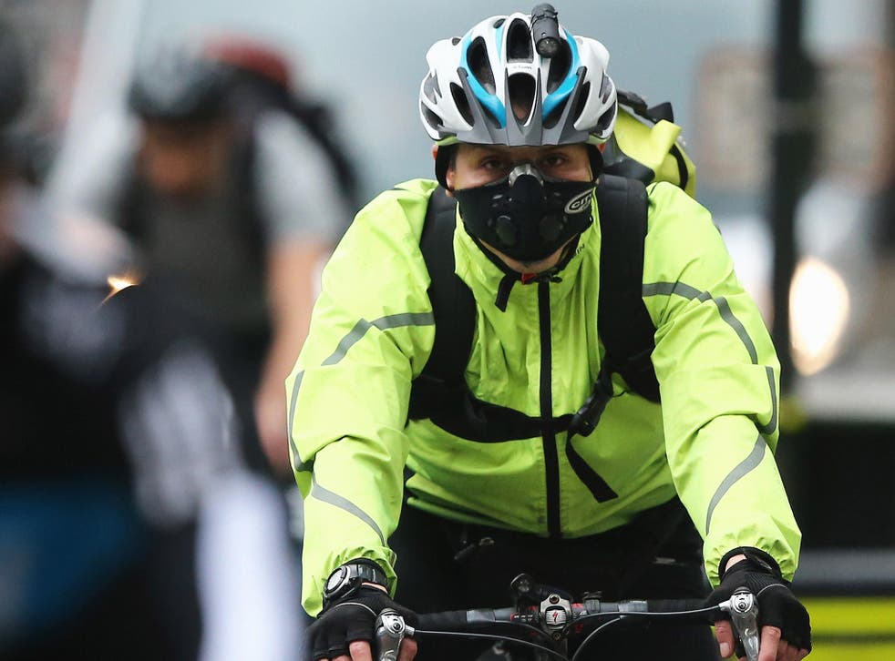 A cyclist wears a face mask to avoid inhaling pollution, in London