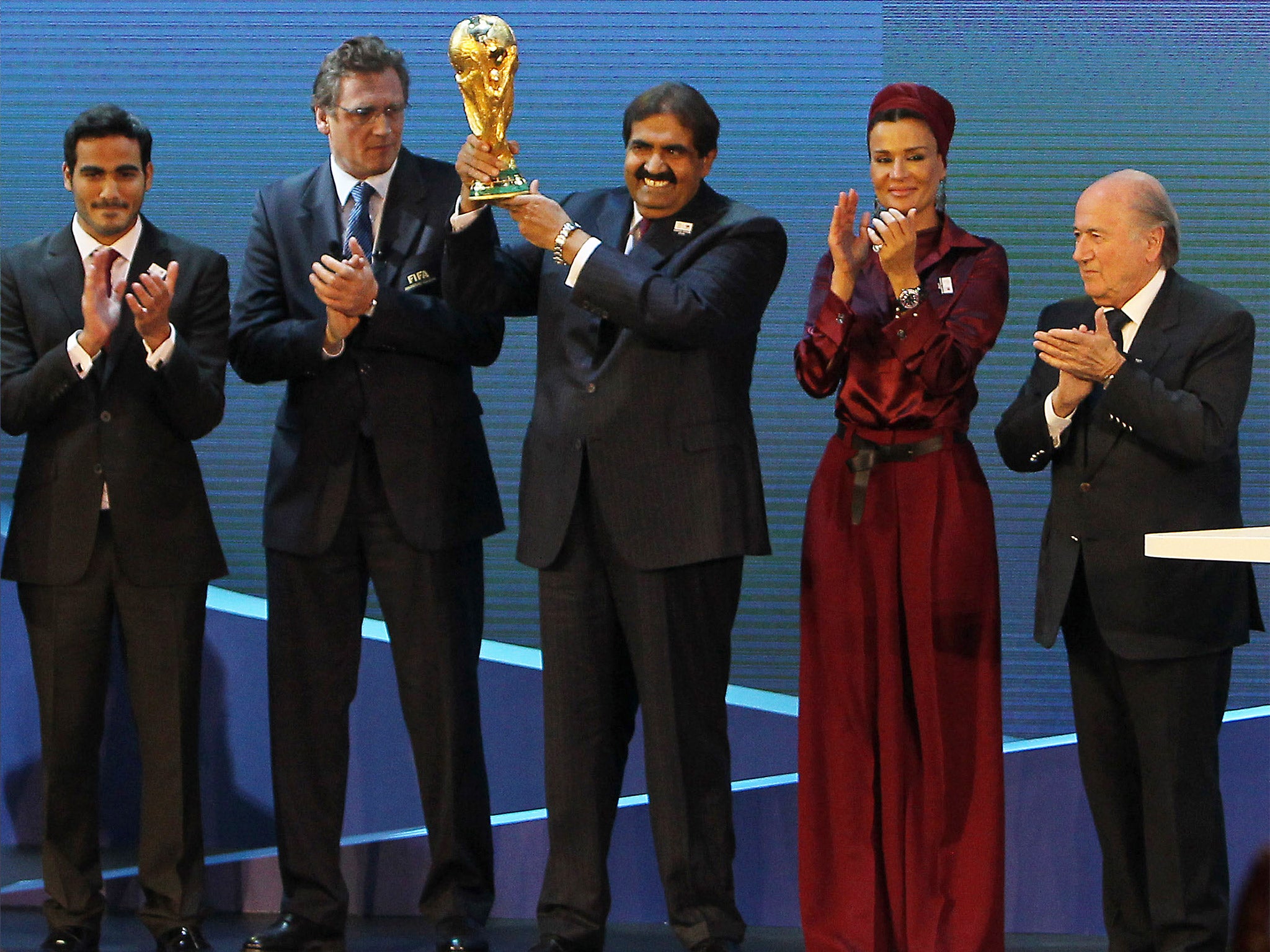 Qatar’s Emir Sheikh Hamad bin Khalifa al-Thani raises the World Cup after winning the vote