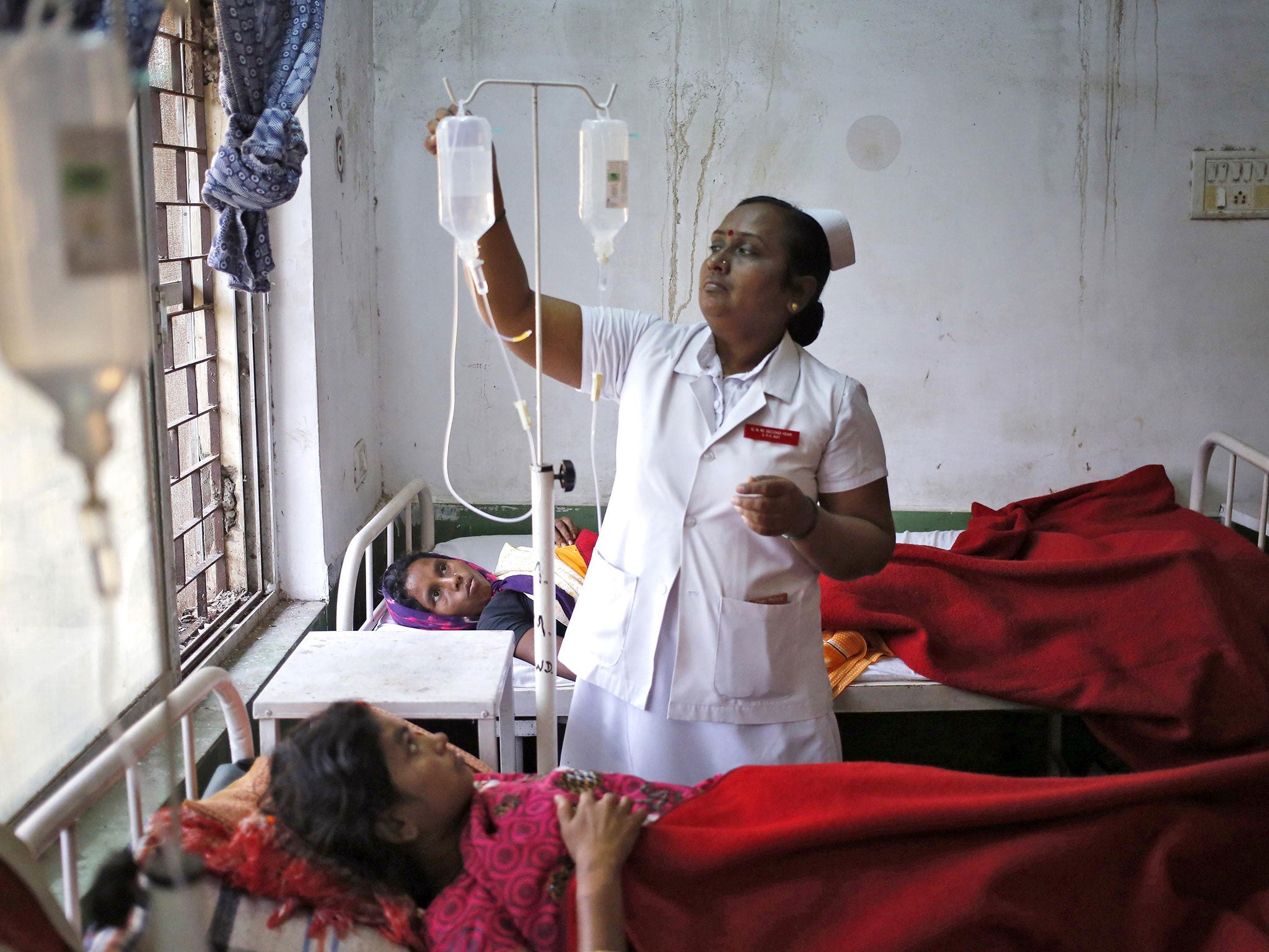 A nurse tends to a woman, who underwent a sterilization surgery at a government mass sterilisation "camp",