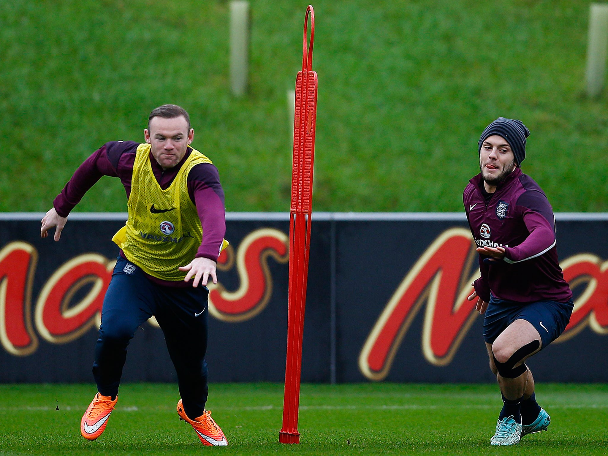 England's Wayne Rooney (L) races Jack Wilshere during a training session at the St George's Park training complex near Burton-upon-Trent, central England