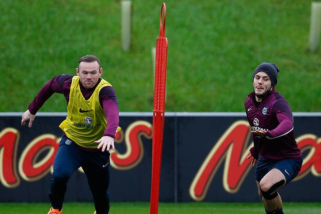 England's Wayne Rooney (L) races Jack Wilshere during a training session at the St George's Park training complex near Burton-upon-Trent, central England 