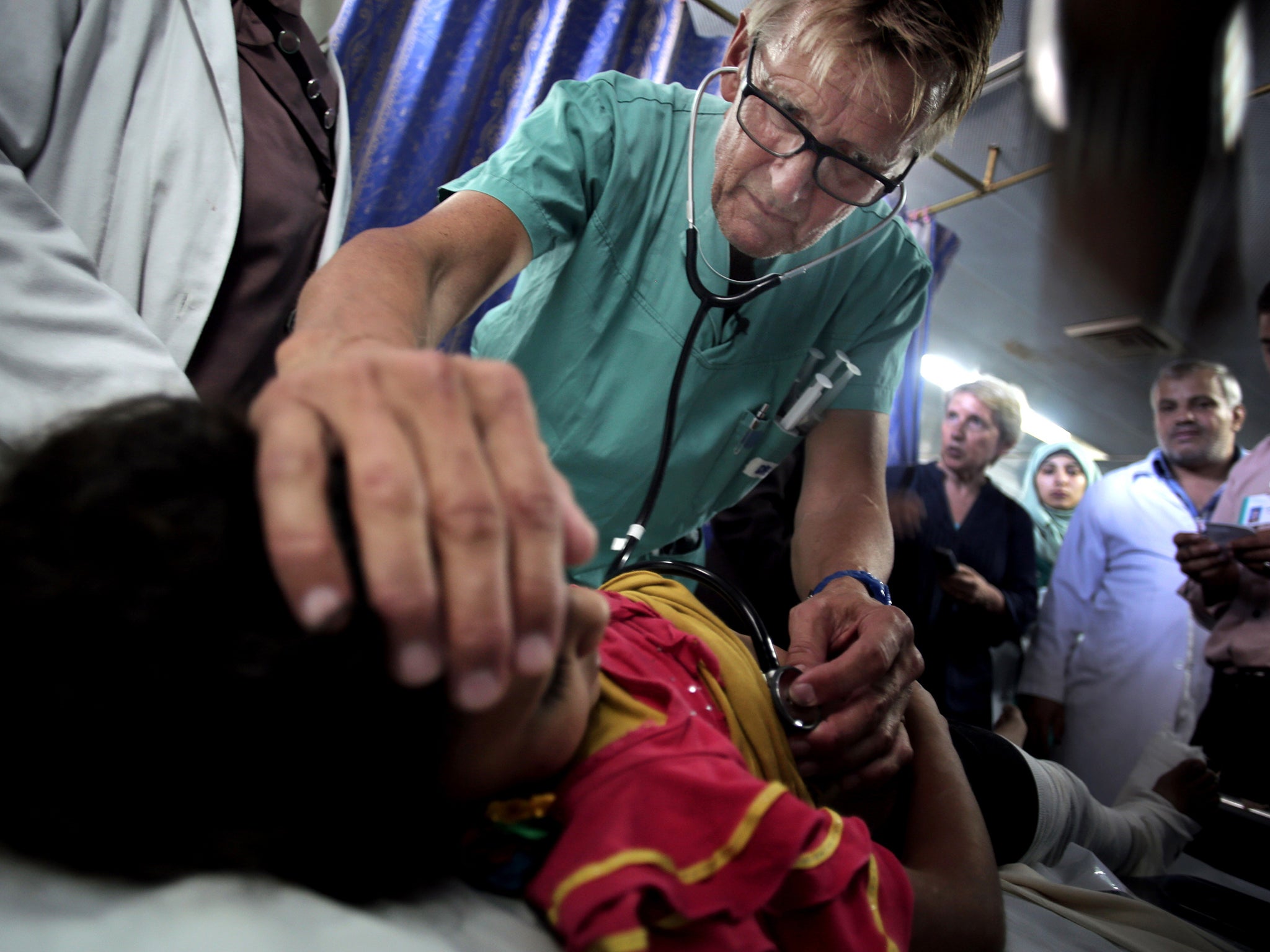 Dr Mads Gilbert, seen here tending a Palestinian child, says the ban is not about him but about denying medical aid to Gaza