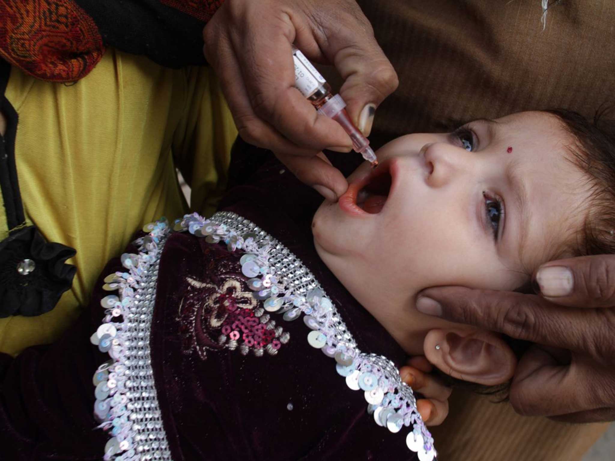 A Pakistani child receives a polio vaccine