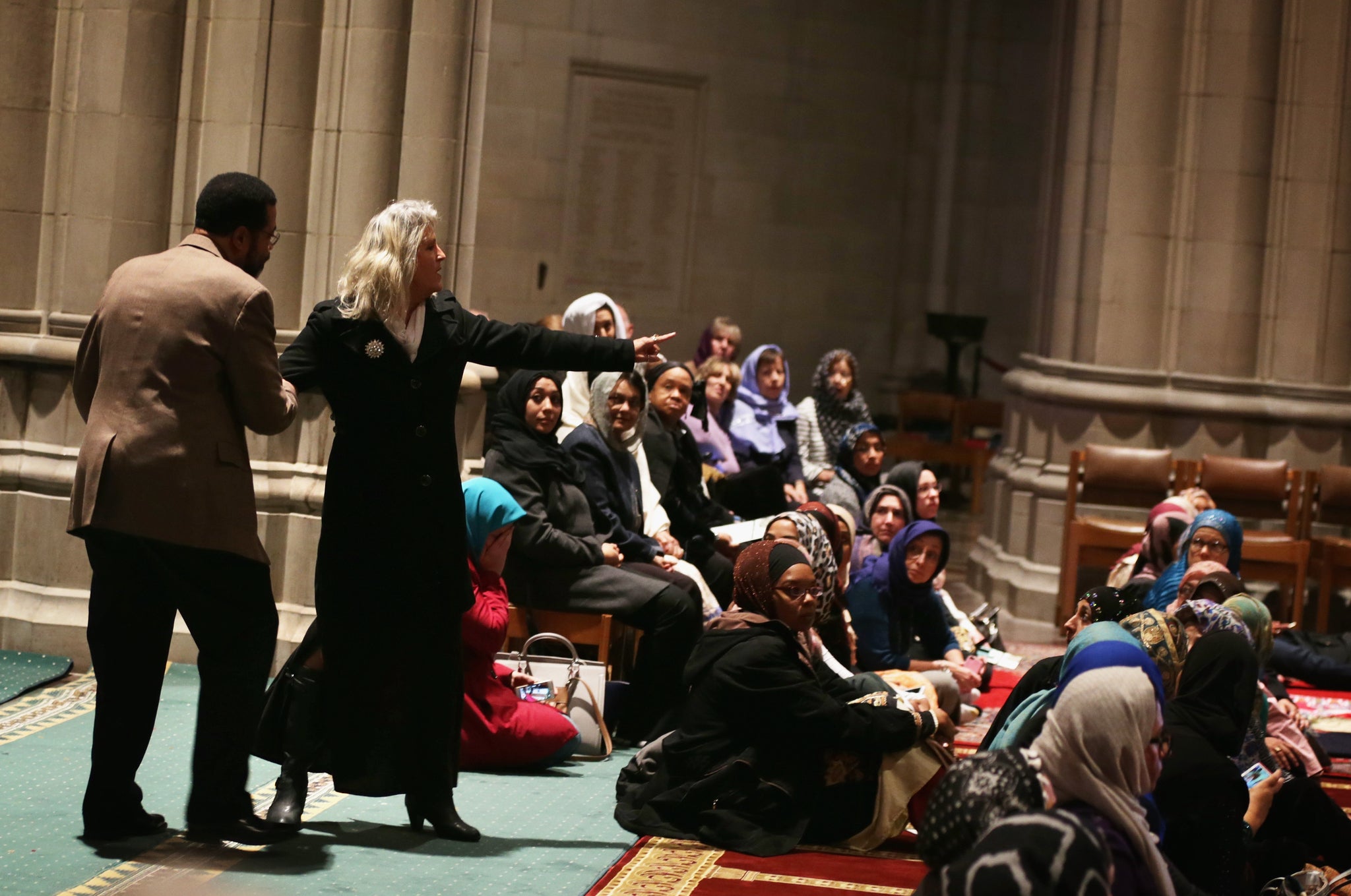 A cathedral employee tries to stop a woman from protesting prior to a Friday prayer November 14 at the National Cathedral in Washington, DC.