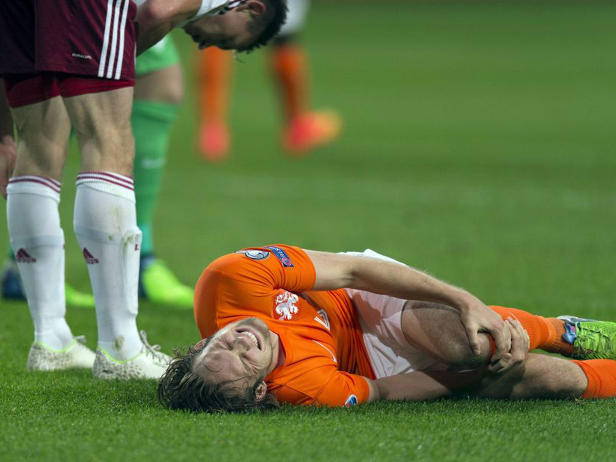 Daley Blind of the Netherlands lies injured after a challenge with Latvia's Eduards Viskanovs during their Euro 2016 Group A qualifier