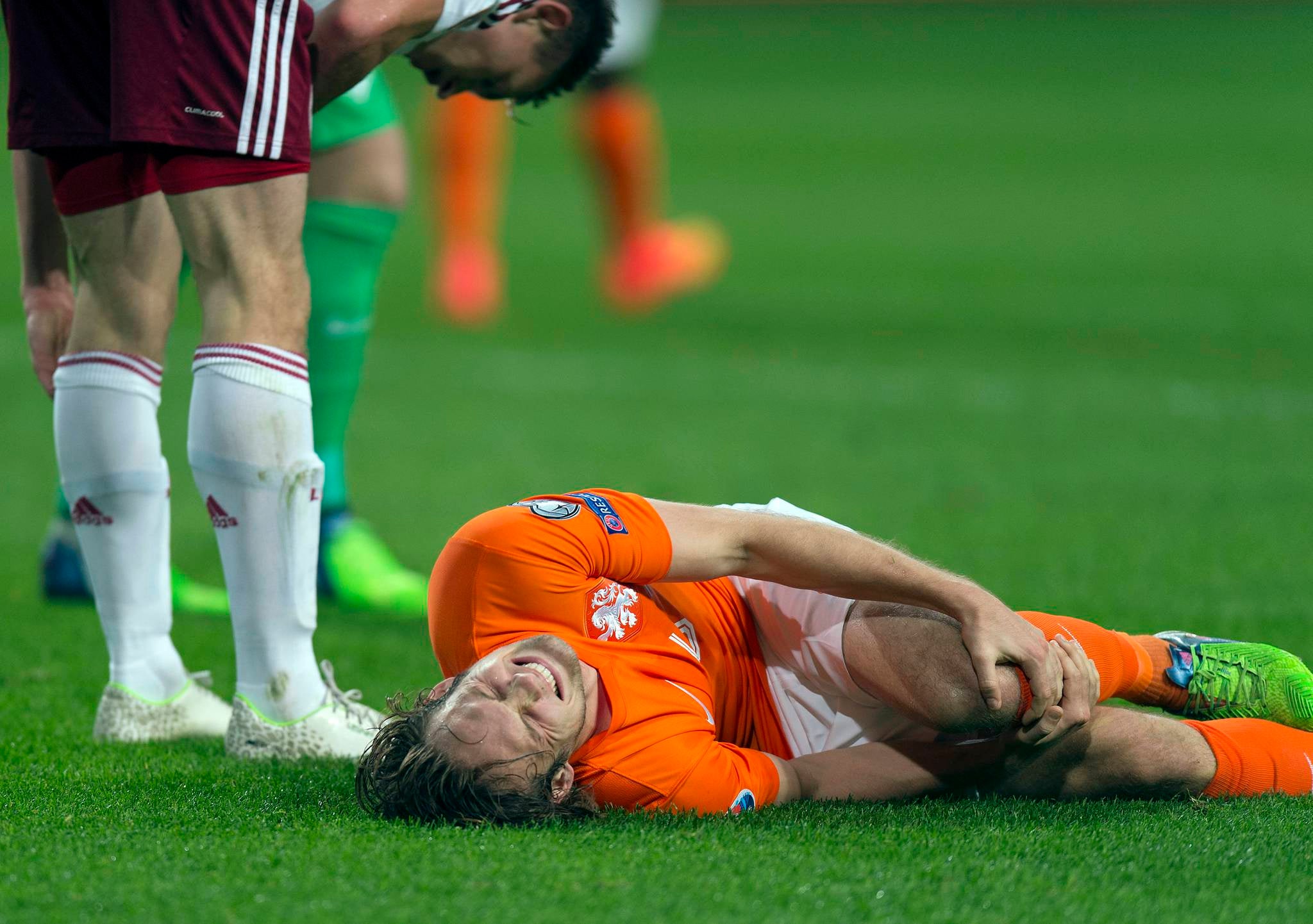 Daley Blind of the Netherlands lies injured after a challenge with Latvia’s Eduards Viskanovs in Amsterdam