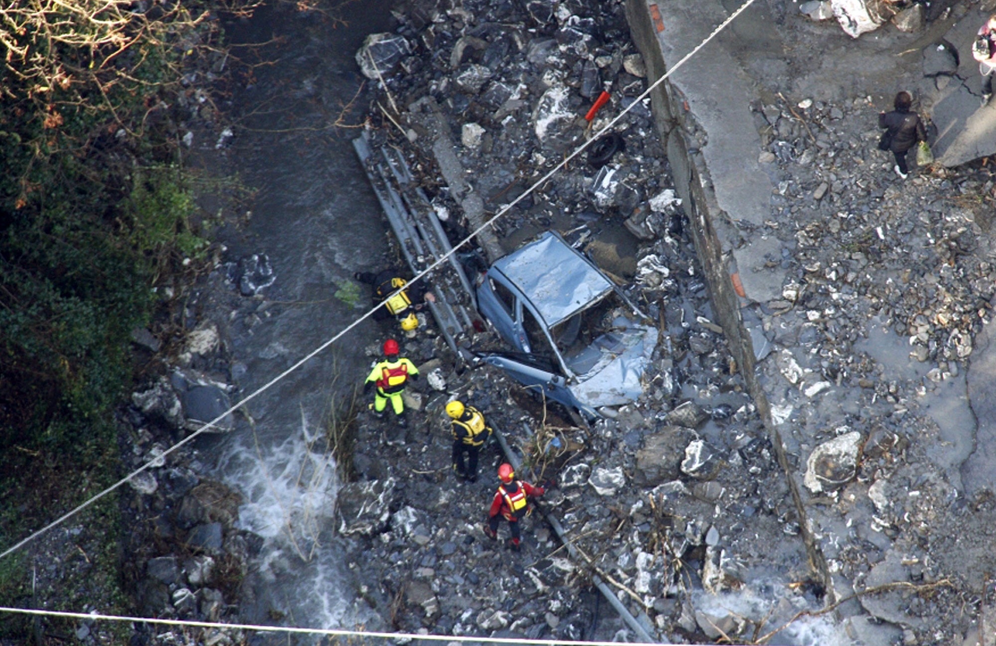 Italian firefighters recover a car that was swept away, near Genoa, northern Italy.