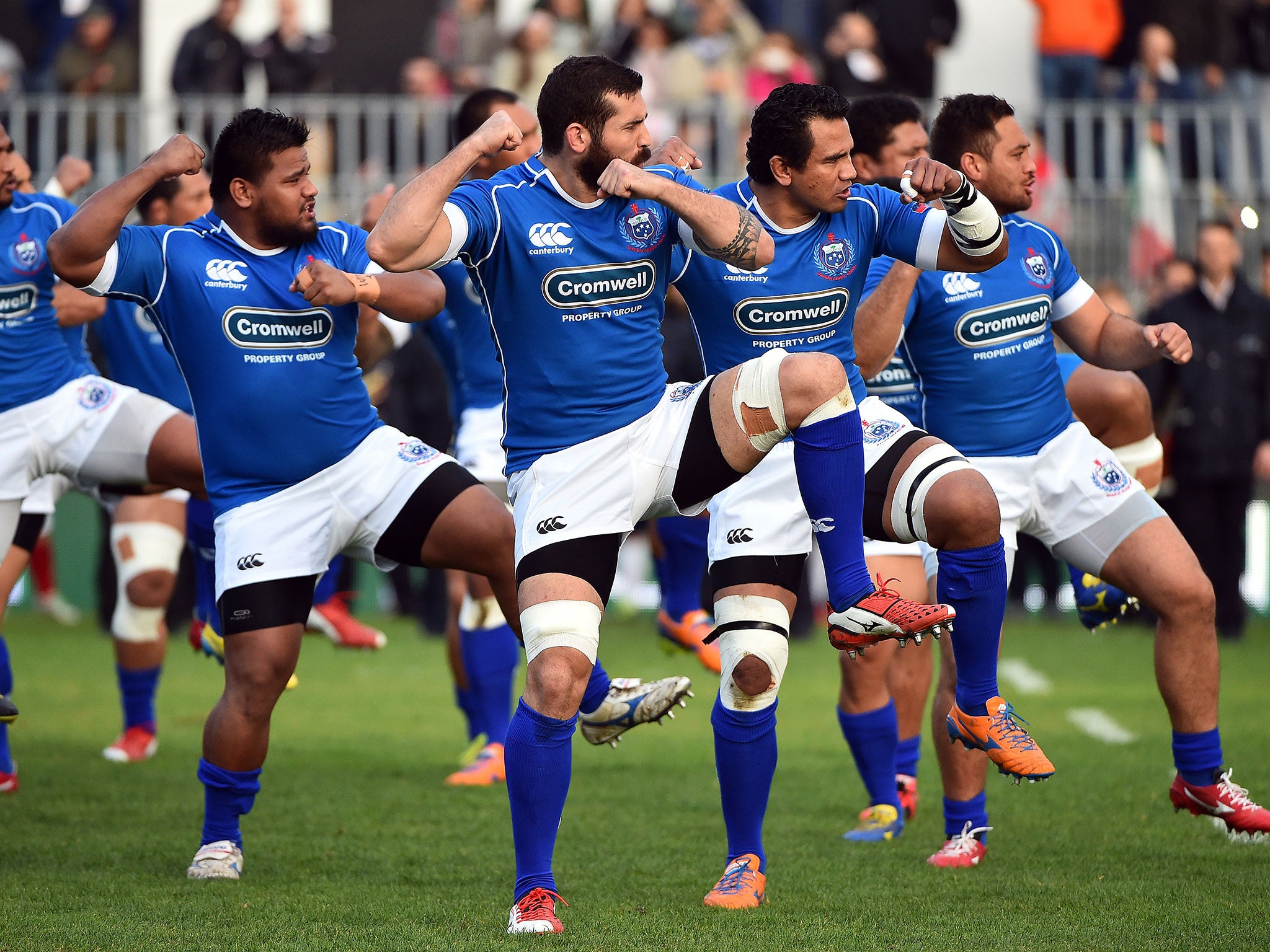 Samoa perform their traditional Siva Tau war dance before the match against Italy