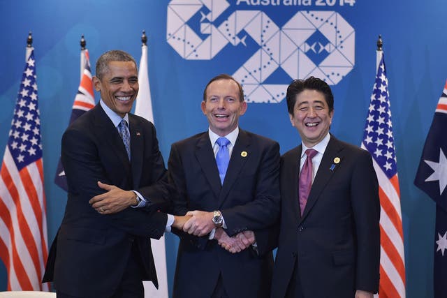 US President Barack Obama (L) , Australia's Prime Minister Tony Abbott (C) and Japan's Prime Minister Shinzo Abe (R) shake hands while posing for photos ahead of a trilateral meeting on the sidelines of the G20 Summit in Brisbane 