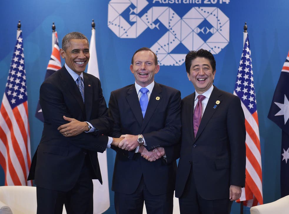 US President Barack Obama (L) , Australia's Prime Minister Tony Abbott (C) and Japan's Prime Minister Shinzo Abe (R) shake hands while posing for photos ahead of a trilateral meeting on the sidelines of the G20 Summit in Brisbane 