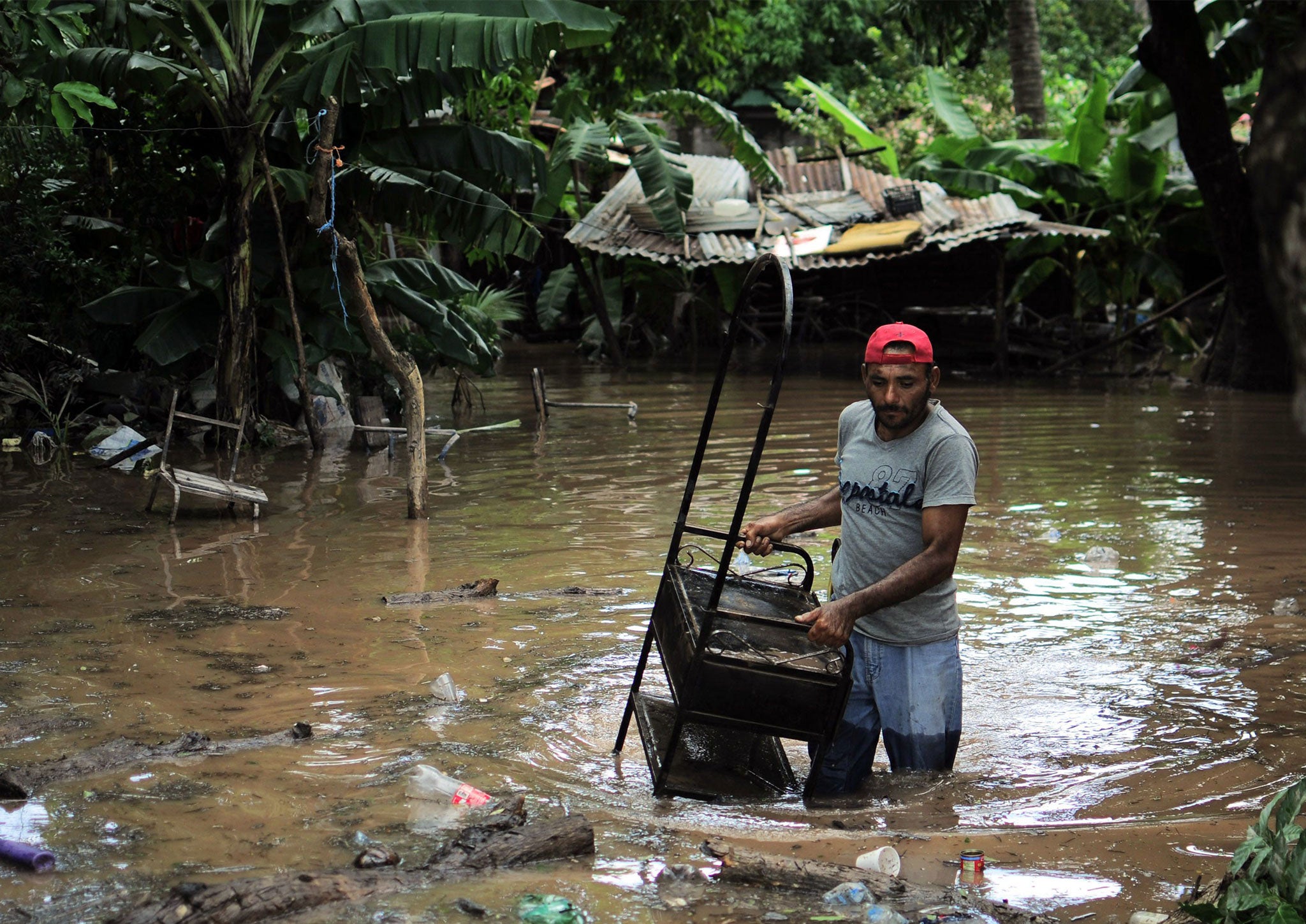 A man rescues his belongings after his home was affected by floods in Marcovia, Honduras