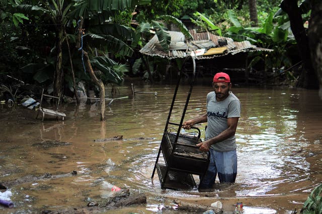 A man rescues his belongings after his home was affected by floods in Marcovia, Honduras