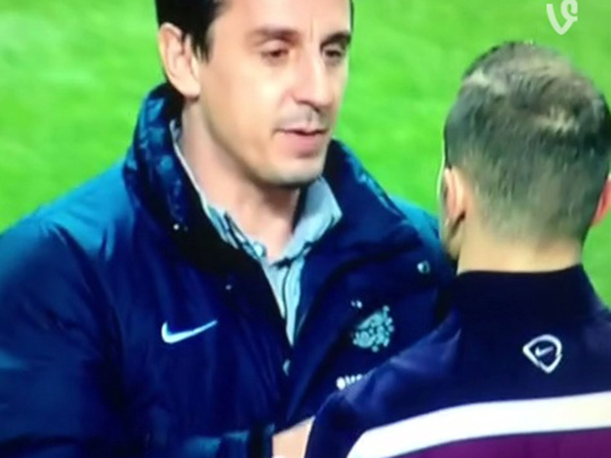 Gary Neville takes out Jack Wilshere's earphones before the Scotland-England match