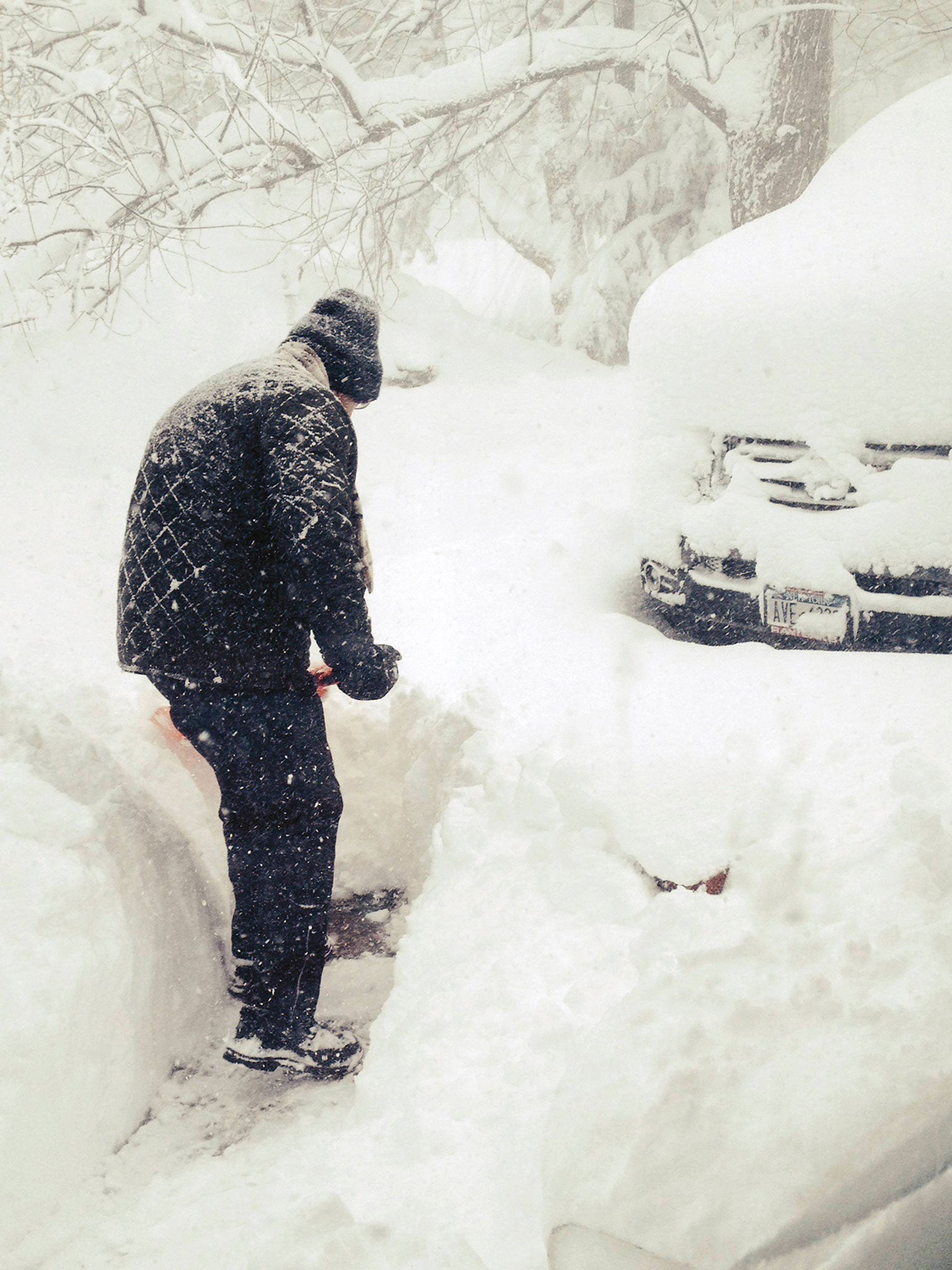 Steven Gros shovels snow from outside his home in Orchard Park