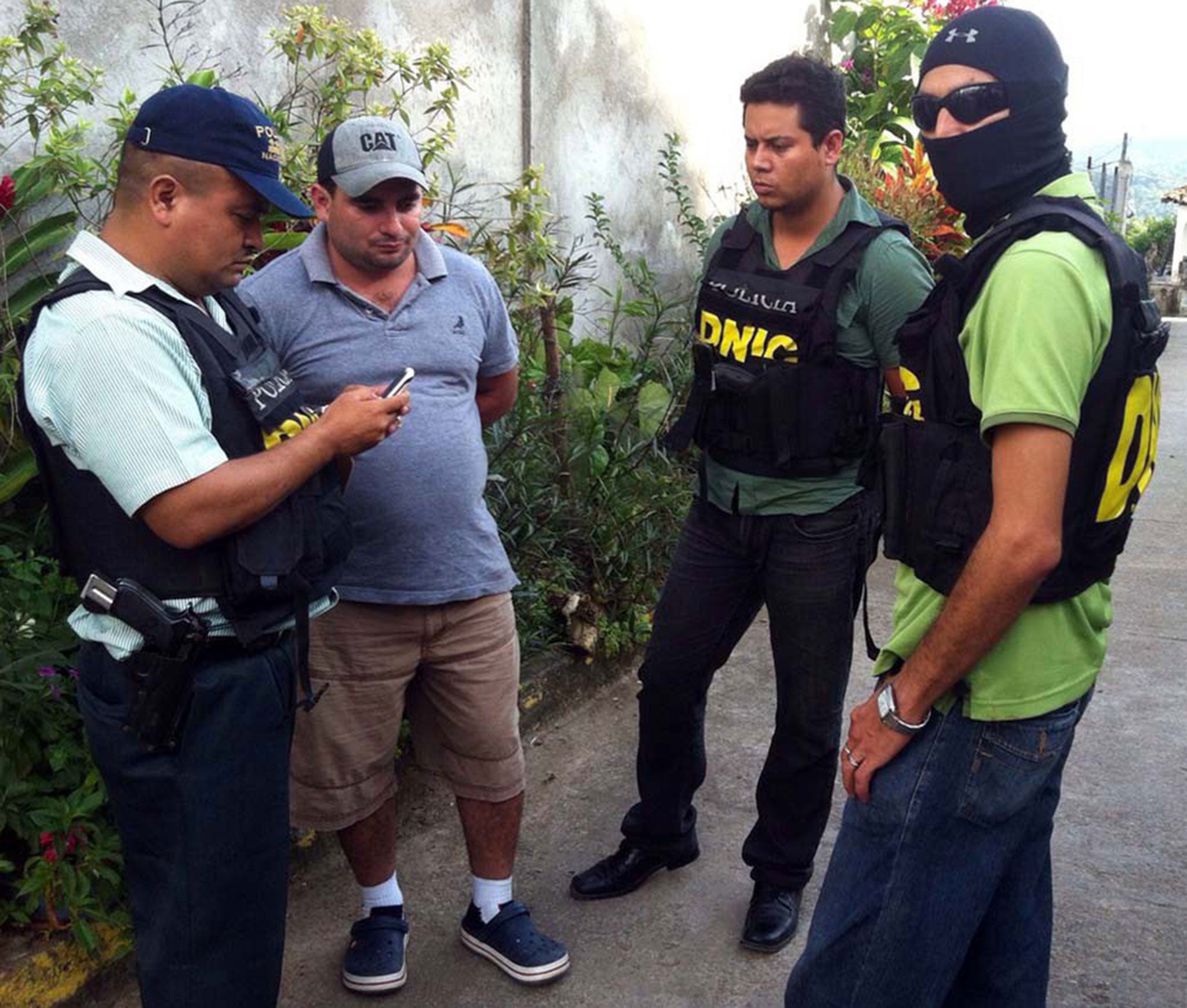 National Police agents escort Plutarco Antonio Ruiz (2nd-L), the boyfriend of Miss Honduras Maria Jose Alvarado's sister in Santa Barbara