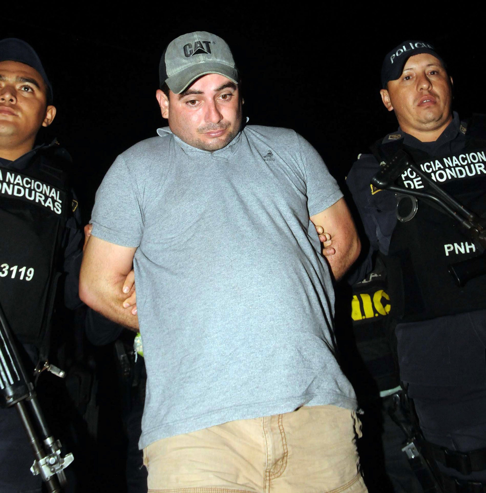 National Police agents escort Plutarco Antonio Ruiz, the boyfriend of Miss Honduras Maria Jose Alvarado's sister in Santa Barbara