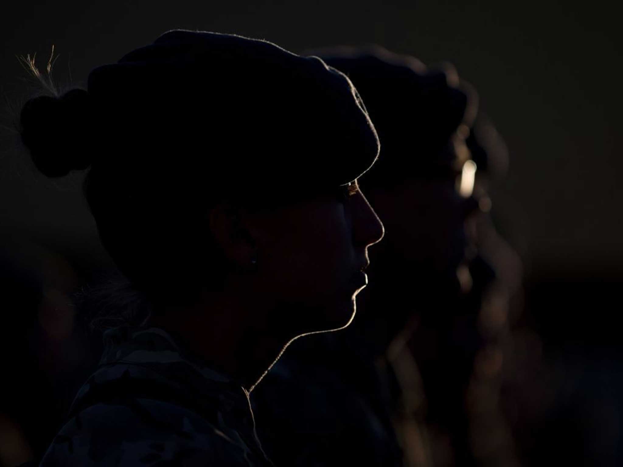A female solider is outlined by light in Kandahar Base in Afghanistan