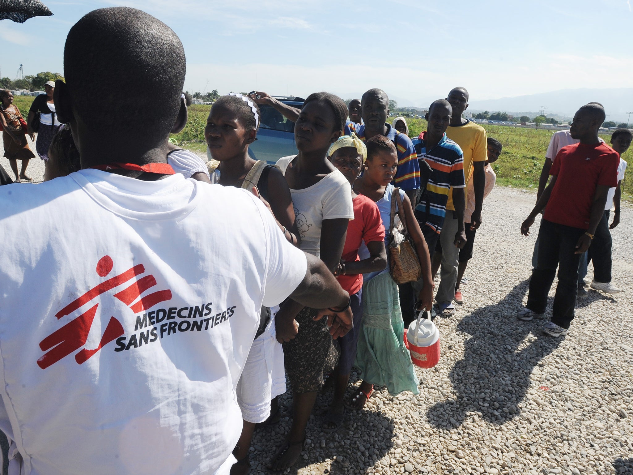 Relatives of cholera patients wait in line for a daily visit at the Doctors Without Borders hospital December 22, 2010 in Sarthe, Haiti