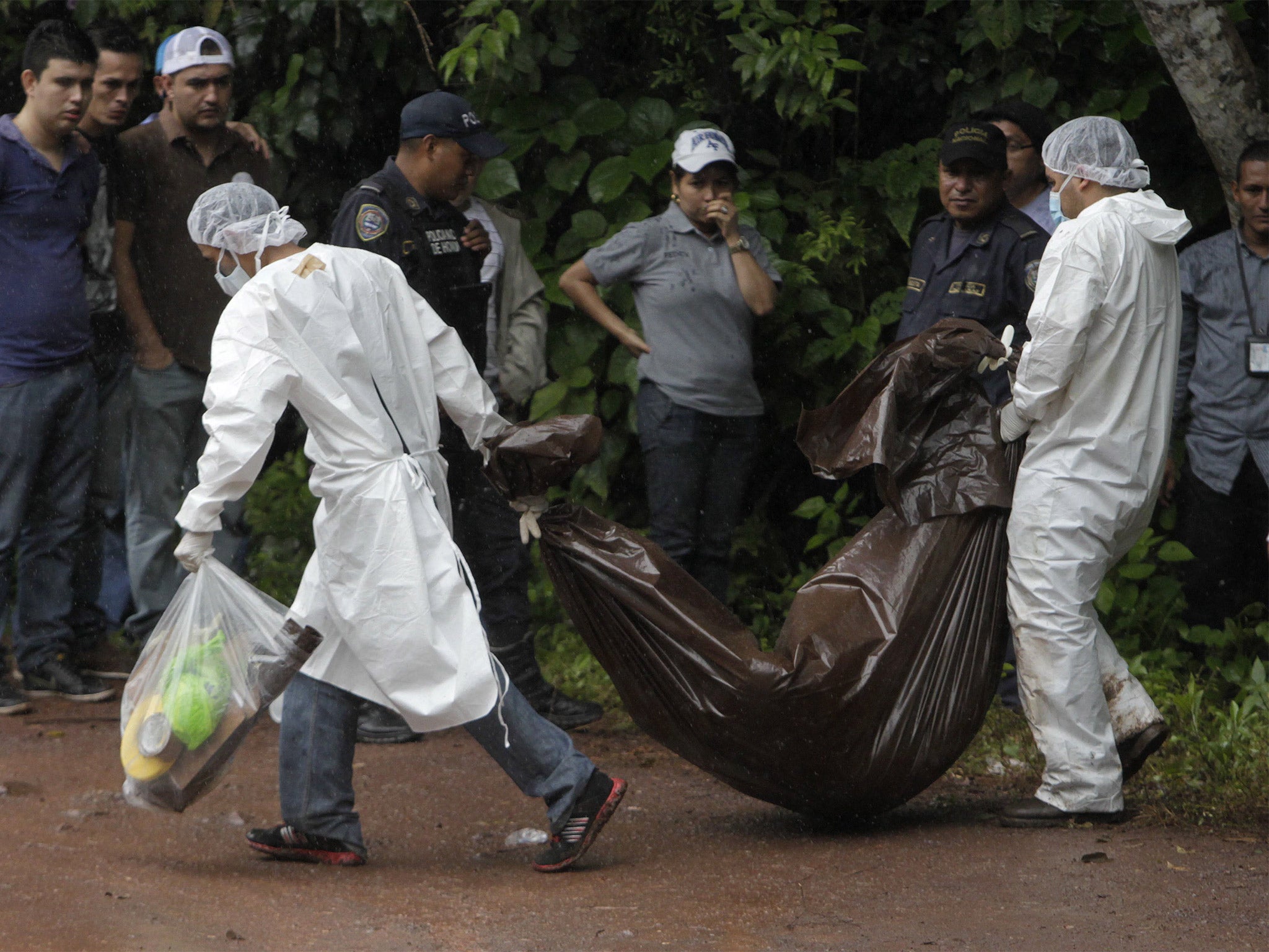 Forensic workers remove a body in the village of Cablotales, near Snata Barbara, Honduras