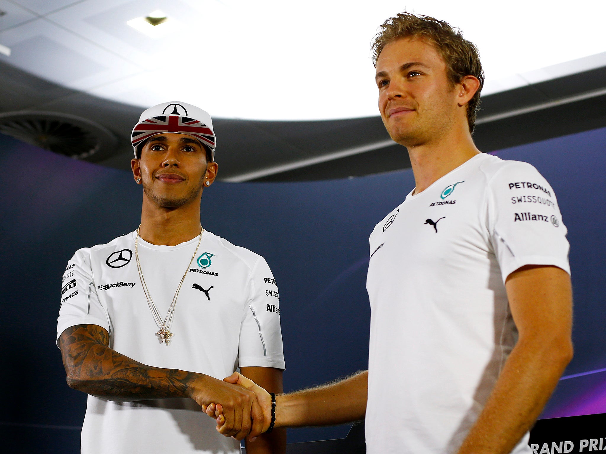 Lewis Hamilton of Great Britain and Mercedes GP shakes hands with Nico Rosberg of Germany and Mercedes GP before the drivers' press conference during previews ahead of the Abu Dhabi Formula One Grand Prix at Yas Marina Circuit on November 20, 2014 in Abu 