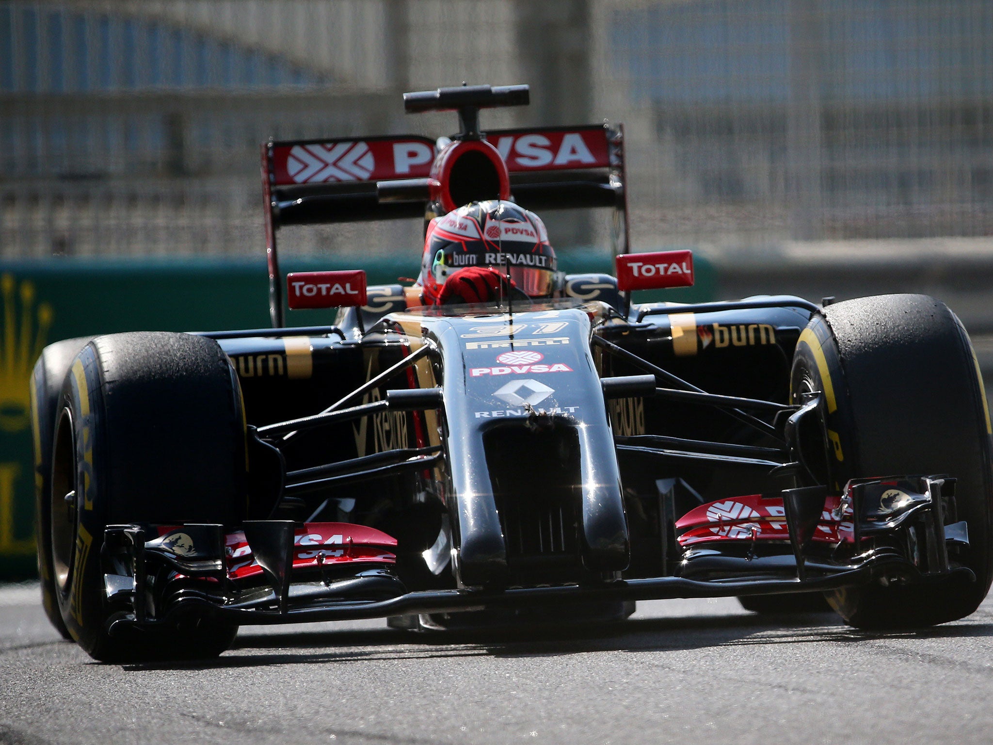 Romain Grosjean turns in as his Lotus glistens in the Abu Dhabi sun
