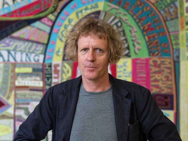 Artist Grayson Perry stands in front of a piece of his entitled 'Comfort Blanket' during a photocall for his 'Who Are You?' exhibition at the National Portrait gallery on October 22, 2014 in London, England.