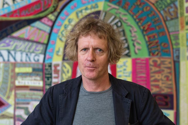 Artist Grayson Perry stands in front of a piece of his entitled 'Comfort Blanket' during a photocall for his 'Who Are You?' exhibition at the National Portrait gallery on October 22, 2014 in London, England.