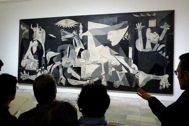 People look at the Guernica painting by Pablo Picasso at the Reina Sofia museum in Madrid on November 16, 2011. 