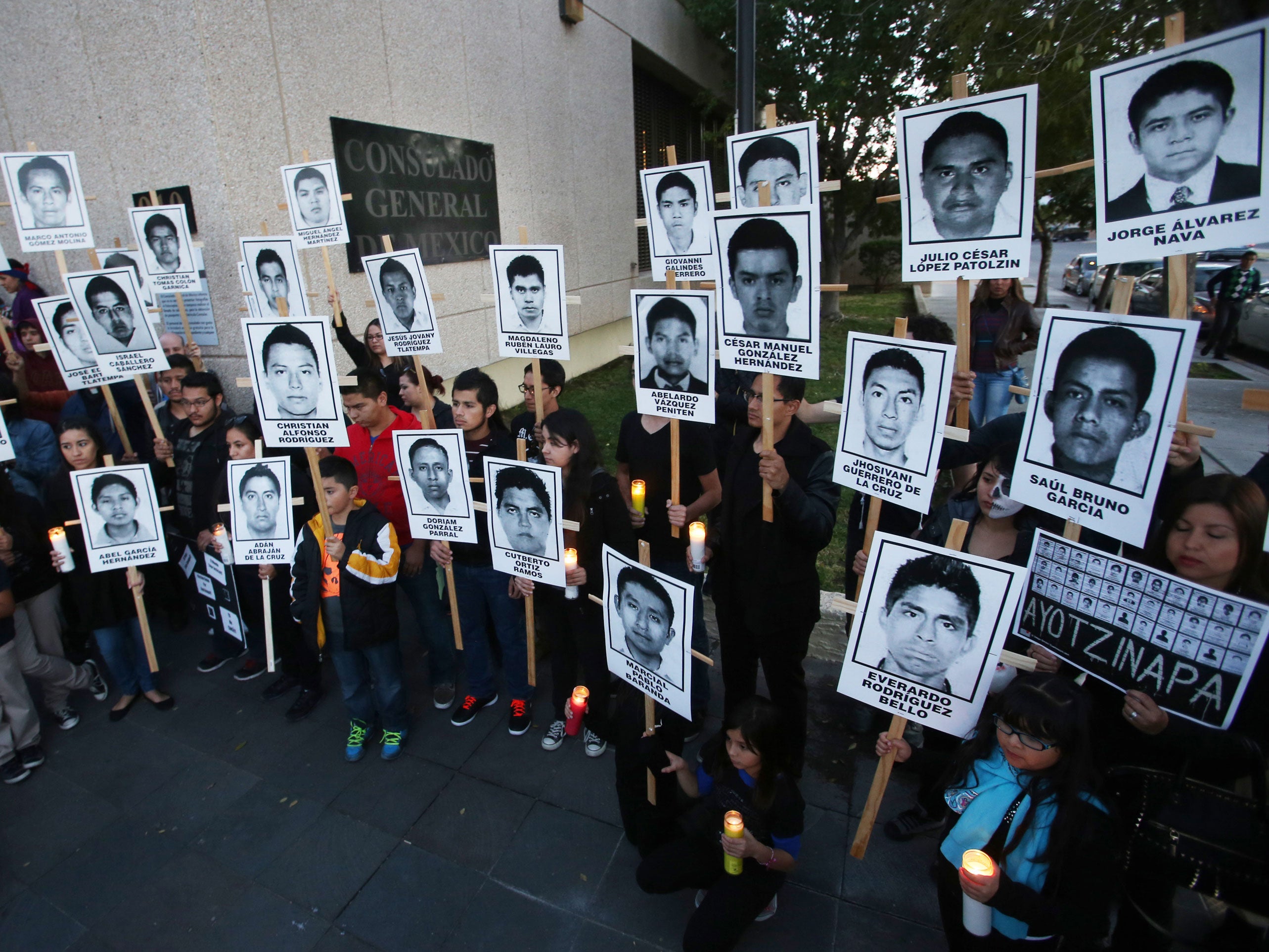 Families and friends of the missing 43 young men holding placards with their names and faces