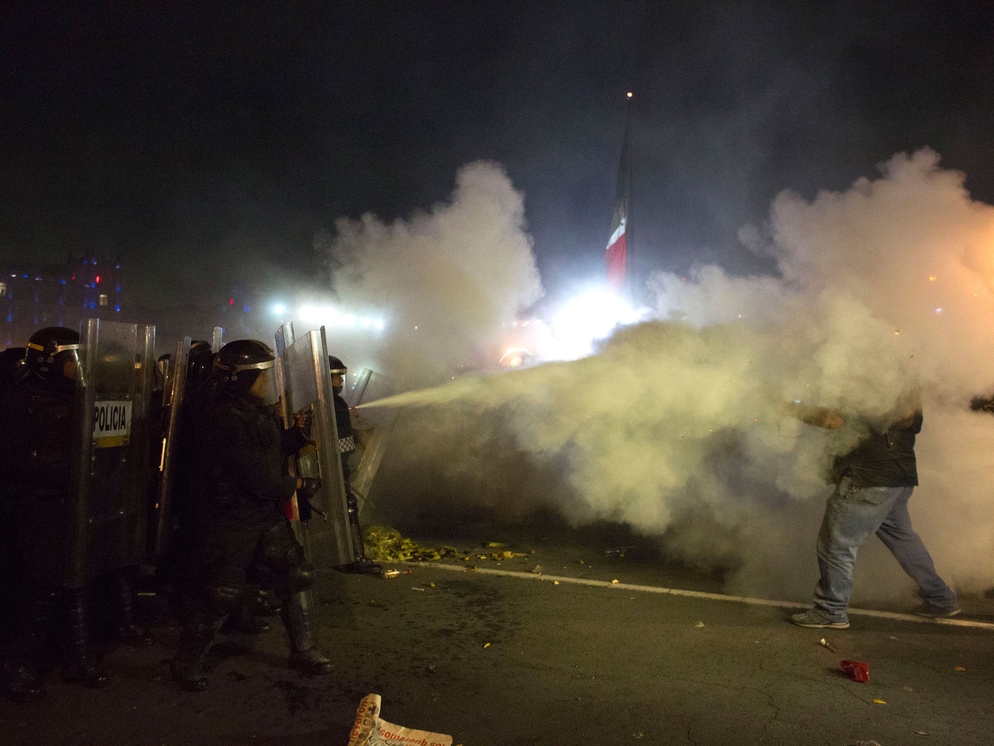 Police use fire extinguishers to ward off masked protesters on 20 November 2014