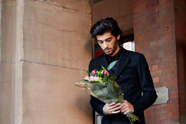 One Direction's Zayn Malik gazes at a bouquet of flowers in the 'Night Changes' music video