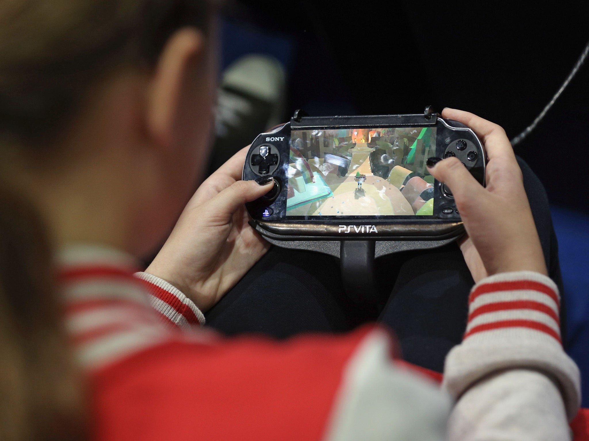 A girl plays on a Sony 'PS Vita' portable games console