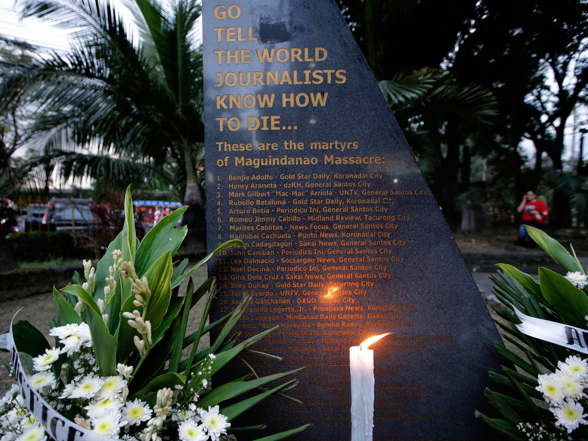 A lone candle lights up the granite marker engraved with the names of the 32 journalists, victims of a massacre in southern Philippines five years ago, outside the National Press Club in Manila, Philippines
