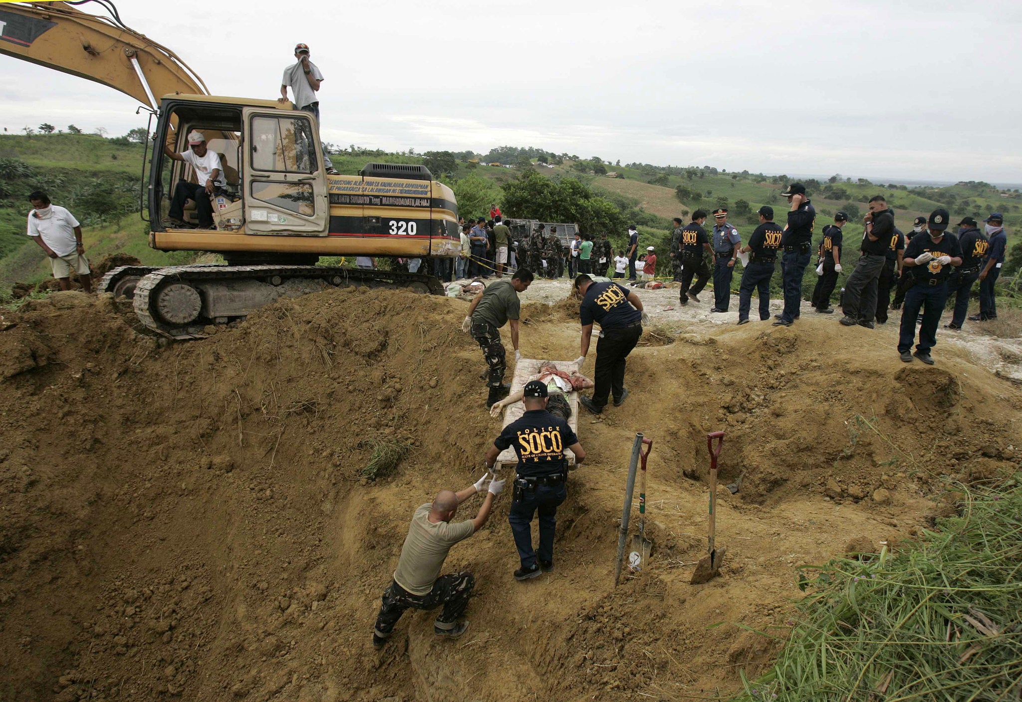 Police officers carry one of dead bodies they recovered along a hillside in Datu Ampatuan, Maguindanao province, southern Philippines. Five years after gunmen flagged down a convoy of cars and massacred all 58 occupants, including scores of journalists, in a southern Philippine province