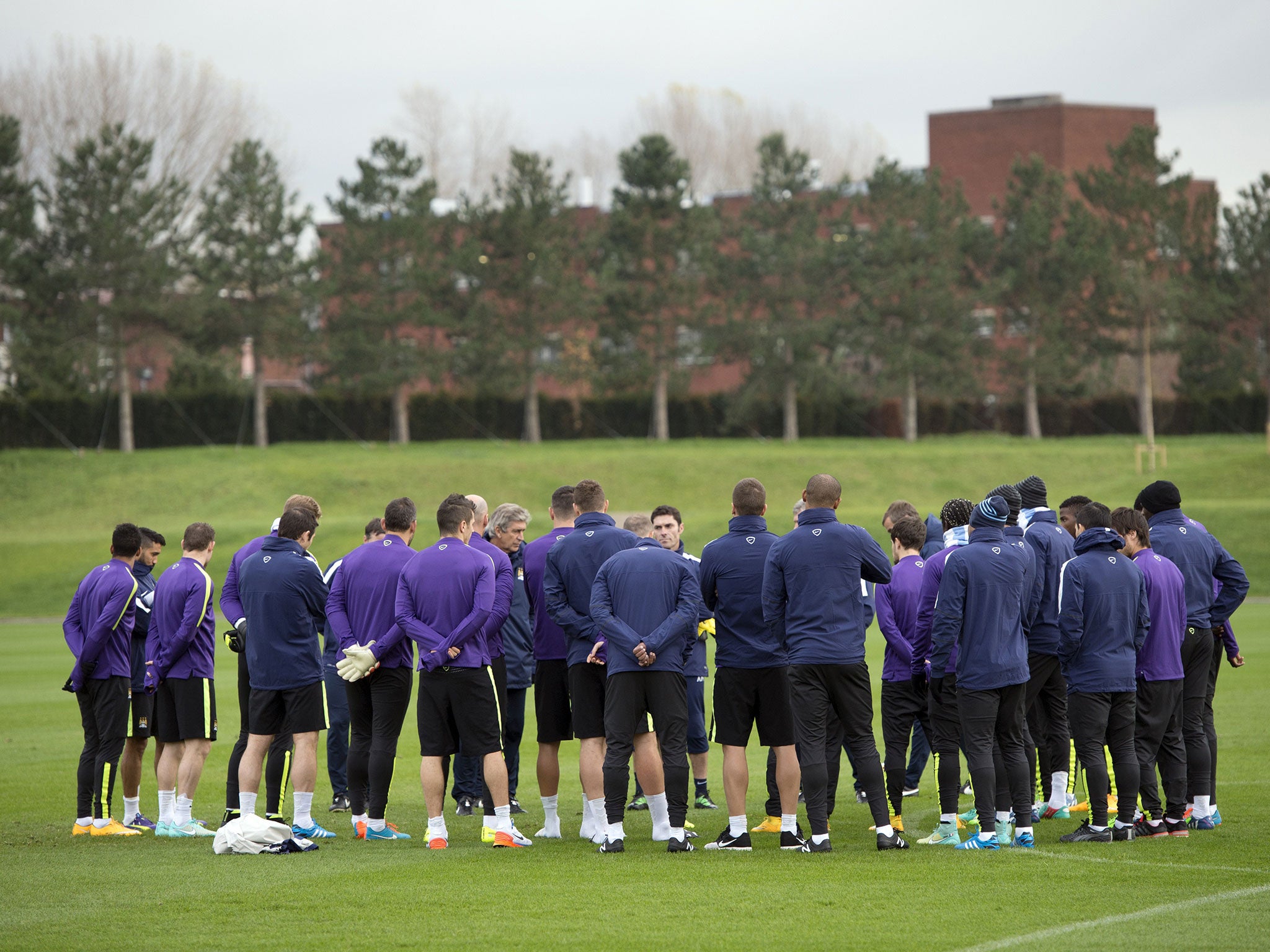 Manuel Pellegrini leads a team talk during Manchester City's training session