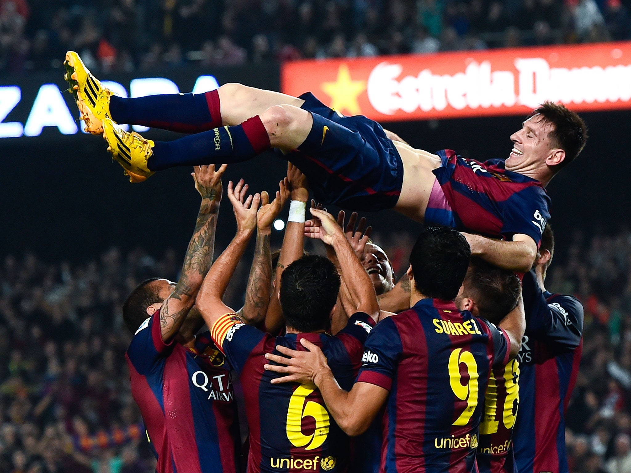 Barcelona players lift up their team-mate Lionel Messi in celebration of his new La Liga goalscoring record