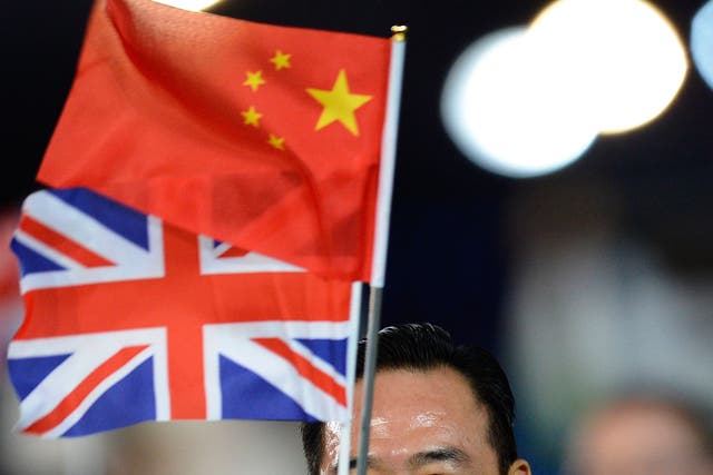 A member of the China's delegation holds a Chinese and a Union Jack flags as he parades during the opening ceremony of the London 2012 Olympic Games