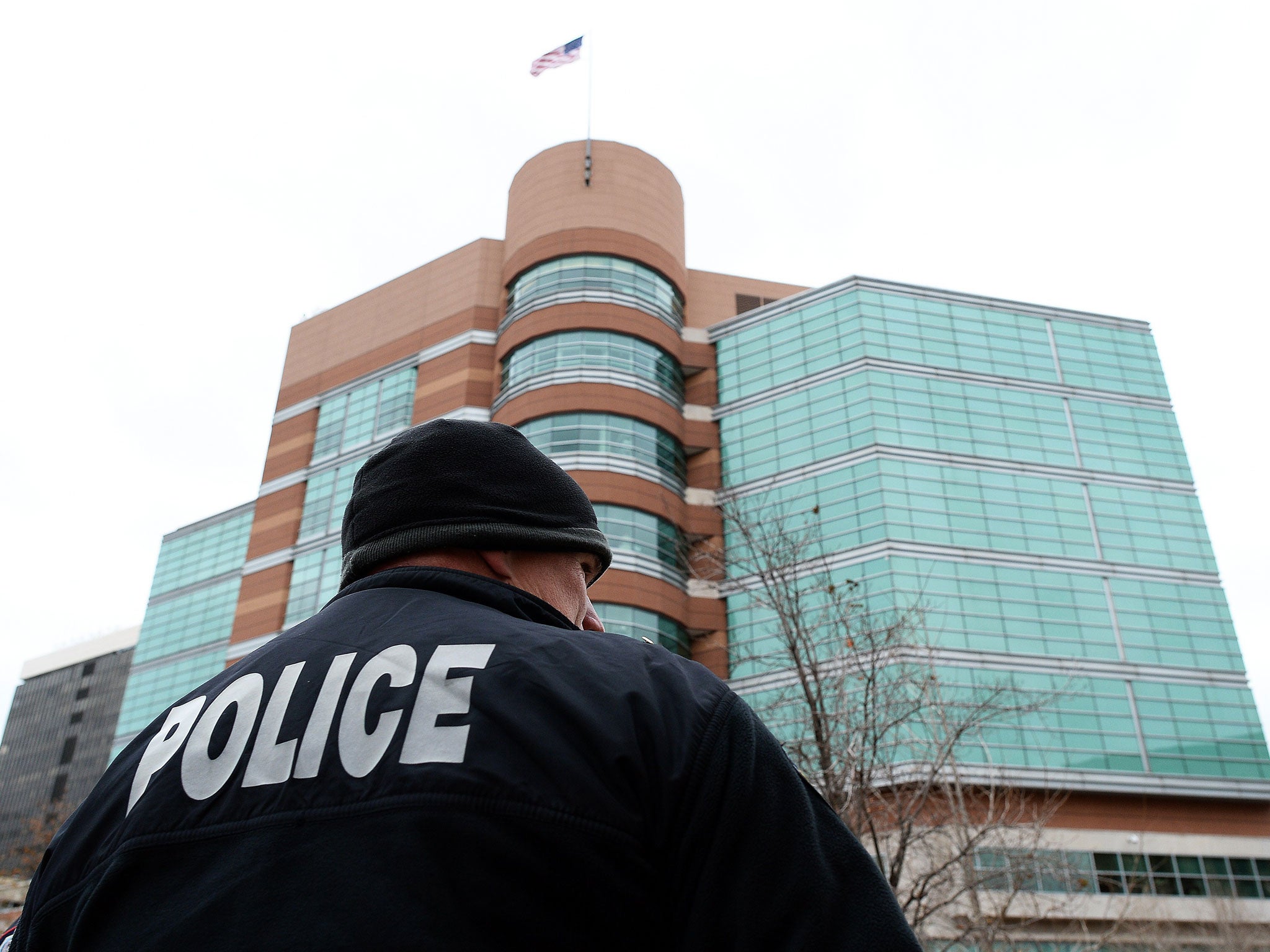 A police officer secures an area around the Buzz Westfall Justice Center in Clayton, Missouri where a grand jury is considering whether to indict a white Ferguson police officer who shot and killed an 18-year-old black teenager, Michael Brown.