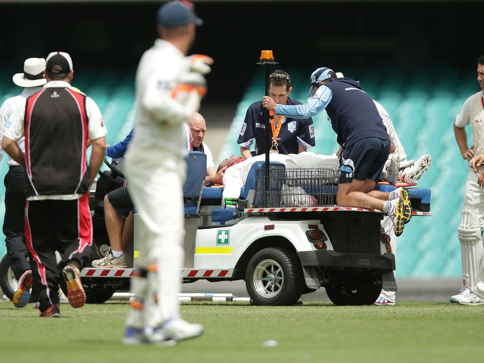 Hughes is carted away before being transported by air to hospital