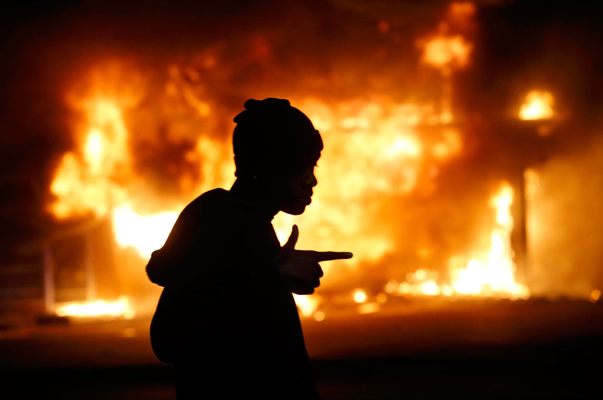 A man walks past a burning building during rioting after a grand jury returned no indictment in the shooting of Michael Brown in Ferguson (Reuters)